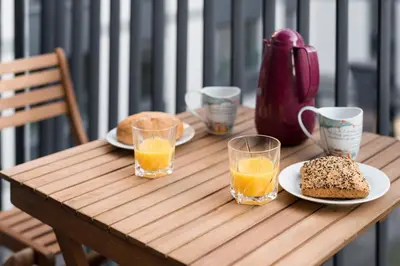a wooden table with plates of food and glasses of orange juice at Old Town, Kazimierz, large luxurious, 2 bedroom 2 bathroom, Airco in Kraków