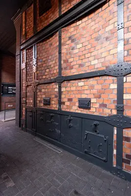 a brick wall with a large black door on it at Old Town, Kazimierz, large luxurious, 2 bedroom 2 bathroom, Airco in Kraków