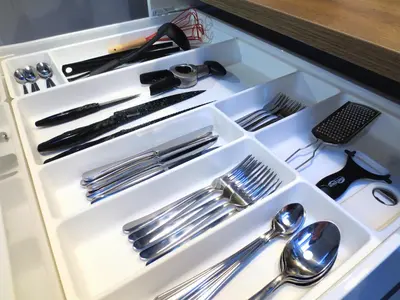 a drawer filled with silver utensils in a cabinet at Apartament krakowski GIMO na Kazimierzu in Kraków
