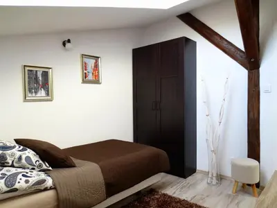 a bedroom with a bed and a wooden door at Apartament krakowski GIMO na Kazimierzu in Kraków