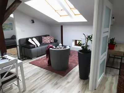 a living room with a couch and a skylight at Apartament krakowski GIMO na Kazimierzu in Kraków
