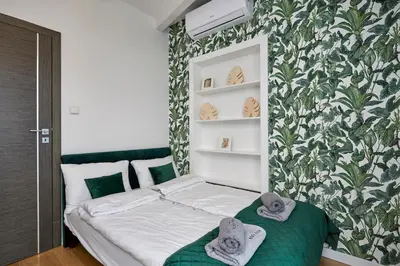 a small bedroom with a bed with towels on it at LUXURIOUS APARTMENTS Cracow in Kraków