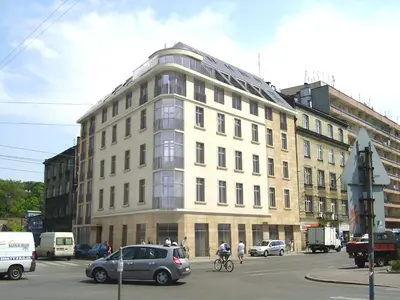 a large white building on a city street with cars at LUXURIOUS APARTMENTS Cracow in Kraków