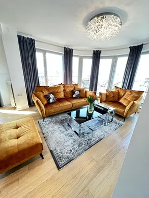a living room with leather furniture and a chandelier at LUXURIOUS APARTMENTS Cracow in Kraków