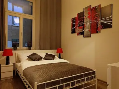 a bedroom with a bed with two lamps and a window at OldKrak Apartment in Kraków