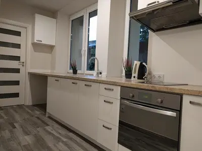 a kitchen with white cabinets and a counter top at OldKrak Apartment in Kraków