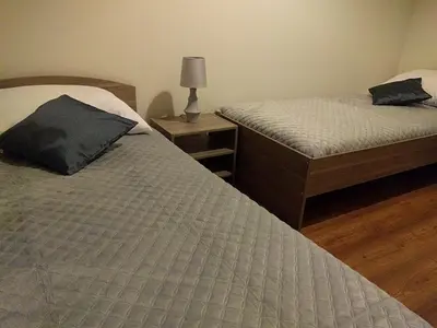 a bedroom with two beds and a lamp on a wooden floor at OldKrak Apartment in Kraków