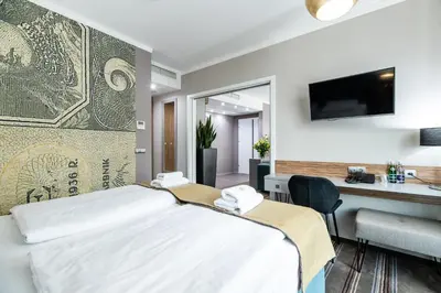 a hotel room with a bed and a desk at Hotel Perfect in Kraków