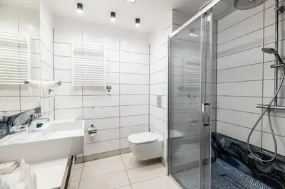 a bathroom with a toilet and a sink and a shower at Hotel Perfect in Kraków