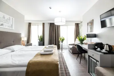 a bedroom with a large bed and a desk with a computer at Hotel Perfect in Kraków