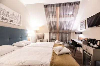 a hotel room with a bed and a desk at Hotel Perfect in Kraków