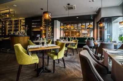 a restaurant with tables and chairs and a bar at Hotel Perfect in Kraków
