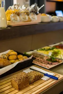 a table with different types of bread and other foods at Hotel Perfect in Kraków