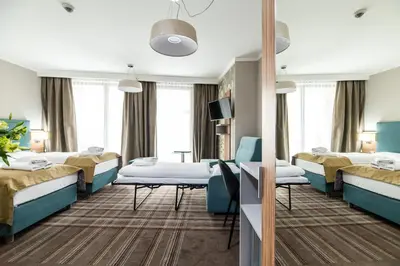 a hospital room with two beds and a table at Hotel Perfect in Kraków