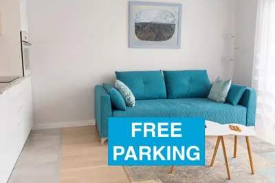 a blue couch in a living room with a sign free parking at Chopin Apartments in Kraków