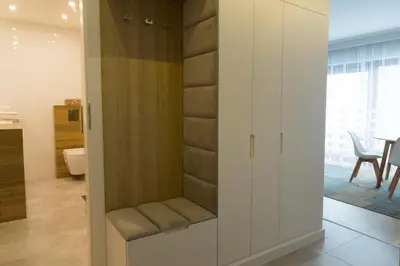 a room with a white closet with a stool at Chopin Apartments in Kraków