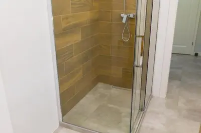 a shower with a glass door in a bathroom at Chopin Apartments in Kraków