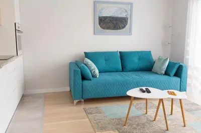 a blue couch in a living room with a table at Chopin Apartments in Kraków