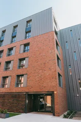 a red brick building with a large glass door at Eight Lux View in Old Town and Free Parking in Kraków