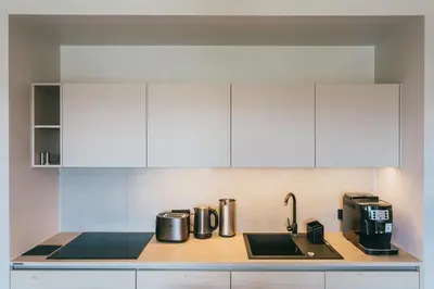 a kitchen with white cabinets and a sink and a coffee maker at Eight Lux View in Old Town and Free Parking in Kraków
