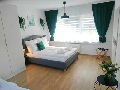 a bedroom with a bed and a window with green curtains at Great Polonia Kraków City Center in Kraków