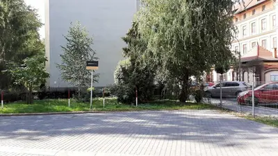 an empty street with a tree and a building at Great Polonia Kraków City Center in Kraków