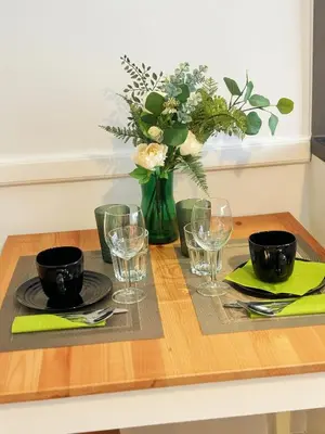 a dining table with a vase of flowers and glasses at Great Polonia Kraków City Center in Kraków