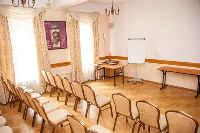 a room with chairs and a podium and a screen at U Pana Cogito in Kraków