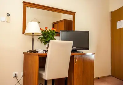 a desk with a television and a chair and a lamp at U Pana Cogito in Kraków