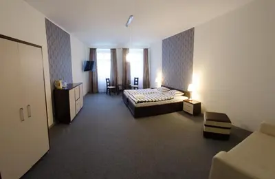 a bedroom with a bed and a couch and a window at Brama Old City Rooms in Kraków