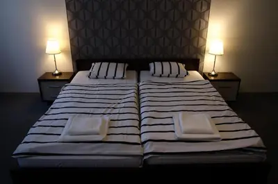 a large bed with two pillows and two lamps at Brama Old City Rooms in Kraków