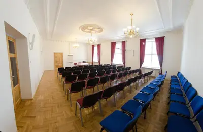 an empty room with chairs and a stage in it at Brama Old City Rooms in Kraków