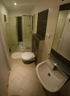 a bathroom with a shower and a toilet and a sink at Brama Old City Rooms in Kraków