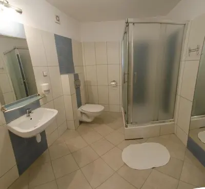 a bathroom with a shower and a toilet and a sink at Brama Old City Rooms in Kraków