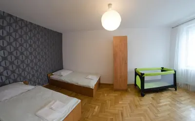 a room with two beds and a table in it at Brama Old City Rooms in Kraków