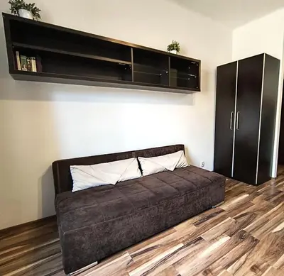 a large bed in a room with a shelf at Apartament Premium in Kraków