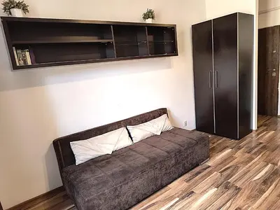 a couch in a living room with a cabinet at Apartament Premium in Kraków
