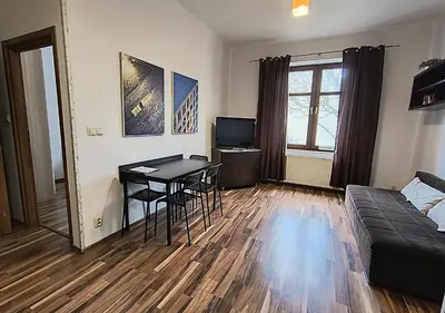 a living room with a table and a couch at Apartament Premium in Kraków