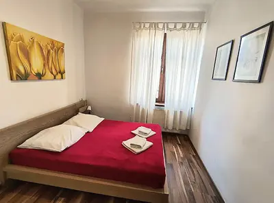 a bedroom with a bed with a red blanket at Apartament Premium in Kraków