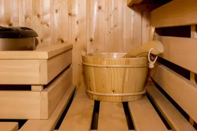 a wooden tub in a cabin with wooden floors at Sauna Luxurious Apartment in Kraków