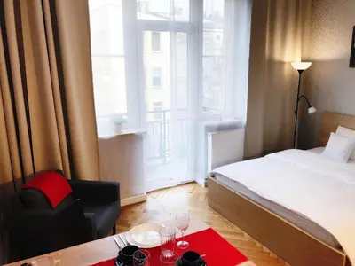 a hotel room with a bed and a table and a window at Apartment III GrayFor2 Old Town Kraków in Kraków