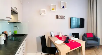 a kitchen with a wooden table with a red table cloth at Apartment III GrayFor2 Old Town Kraków in Kraków