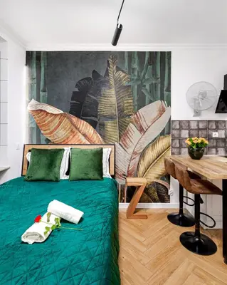 a bedroom with a green bed and a table at Jacuzzi & Bike Apartment, Krakow in Kraków