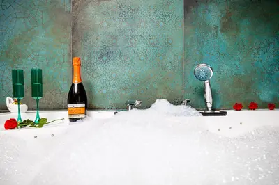 a bottle of wine sitting on top of a bath tub at Jacuzzi & Bike Apartment, Krakow in Kraków
