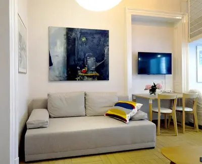 a couch in a living room with a painting on the wall at Art Apartments w centrum Krakowa (Śródmieście, Stradom) in Kraków