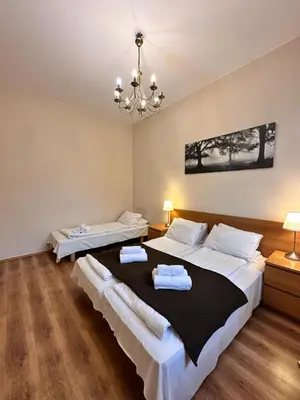 a bedroom with two beds and a chandelier at Mikołajska Apartments with Lift in Kraków
