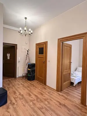 an empty room with a bed and a chandelier at Mikołajska Apartments with Lift in Kraków