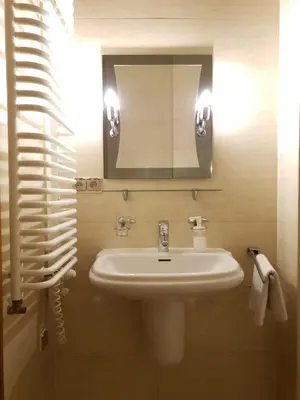 a bathroom with a sink and a mirror at Mikołajska Apartments with Lift in Kraków