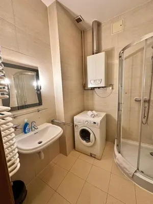 a bathroom with a sink and a washing machine at Mikołajska Apartments with Lift in Kraków