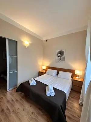 a bedroom with a bed with two towels on it at Mikołajska Apartments with Lift in Kraków